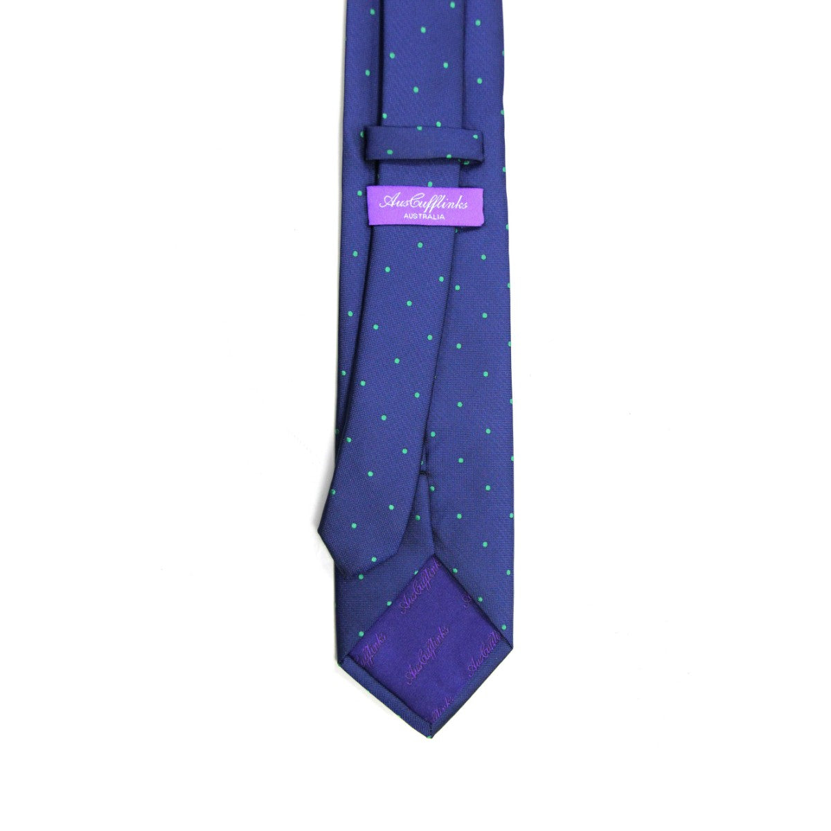 The Navy Green Polka Dot Business Tie & Pocket Square Set features a navy green tie with small green dots, a blue design, and a purple label on the back. It's ideal for embodying the essence of the modern gentleman.
