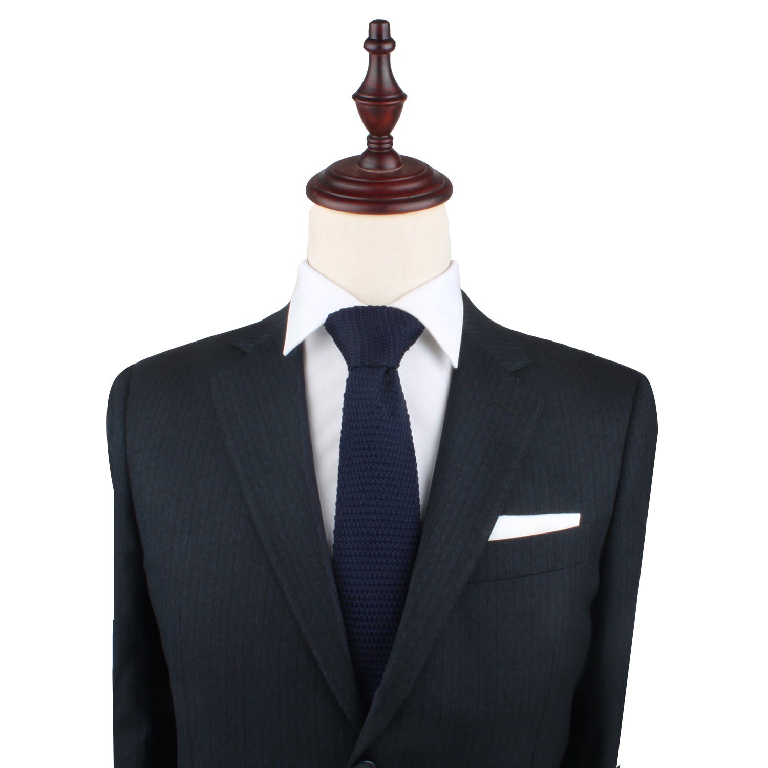 A mannequin dressed in a dark suit, white dress shirt, and a Navy Knit Necktie is displayed against a plain backdrop, exuding an air of elegance.