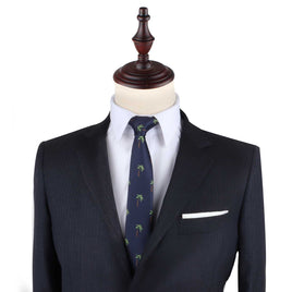 A tailor's mannequin dressed in a dark suit jacket, a white dress shirt, and the Palm Tree Thin Tie featuring a tropical allure palm tree pattern.