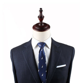 A dark blue pinstripe suit with a white dress shirt and a Penguin Slim Tie is displayed on a mannequin, exuding timeless elegance.