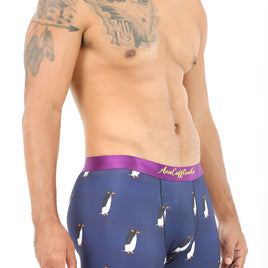 A man wearing Penguin Underwear, featuring a penguin design and a purple waistband, exudes polar comfort as he stands in a studio setting.
