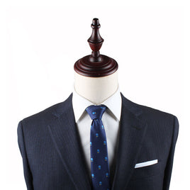 A mannequin dressed in a dark tailored suit with a white dress shirt and a Pickle Ball Slim Tie exudes refined charm, topped with a wooden finial where the head would be.