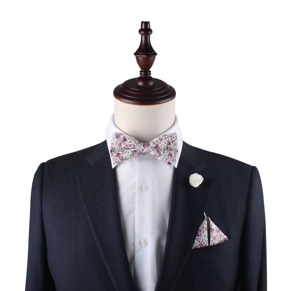 Mannequin dressed in a dark suit jacket with a white shirt, Pink Roses Floral Bow Tie, matching pocket square, and a white lapel pin—all elegantly accessorized with Nature's touch.