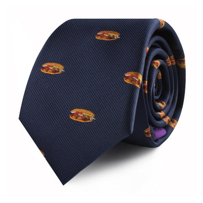 A rolled-up Pork Roll Slim Tie in navy blue, featuring a playful pattern of small hamburger images scattered across the fabric, adding a touch of modern charm inspired by comfort food.