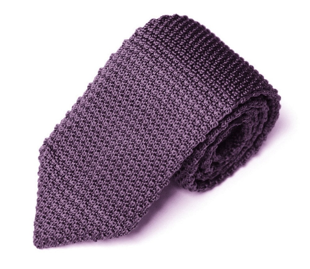 A rolled-up Classic Purple Knit Tie with modern flair on a white background.