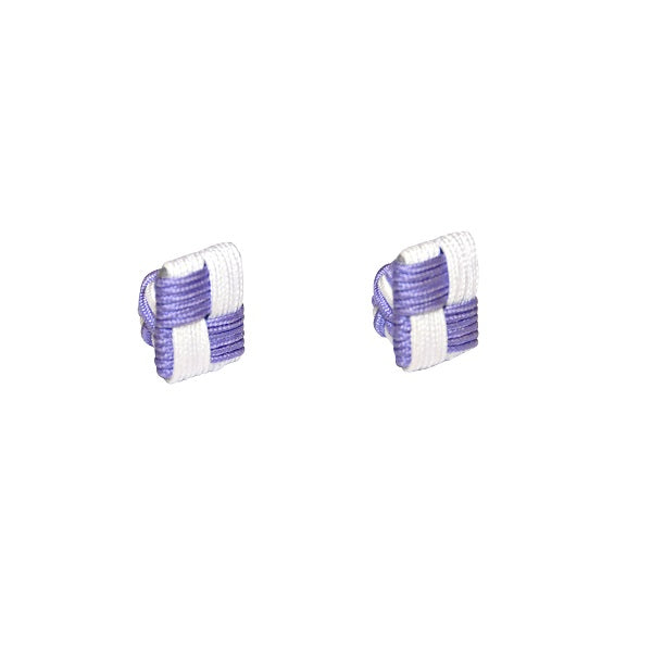 Two small cubic objects showcase a geometric woven pattern in lavender and white on a plain white base, echoing the elegance of AusCufflinks. These are reminiscent of the Purple & White Square Cufflinks.