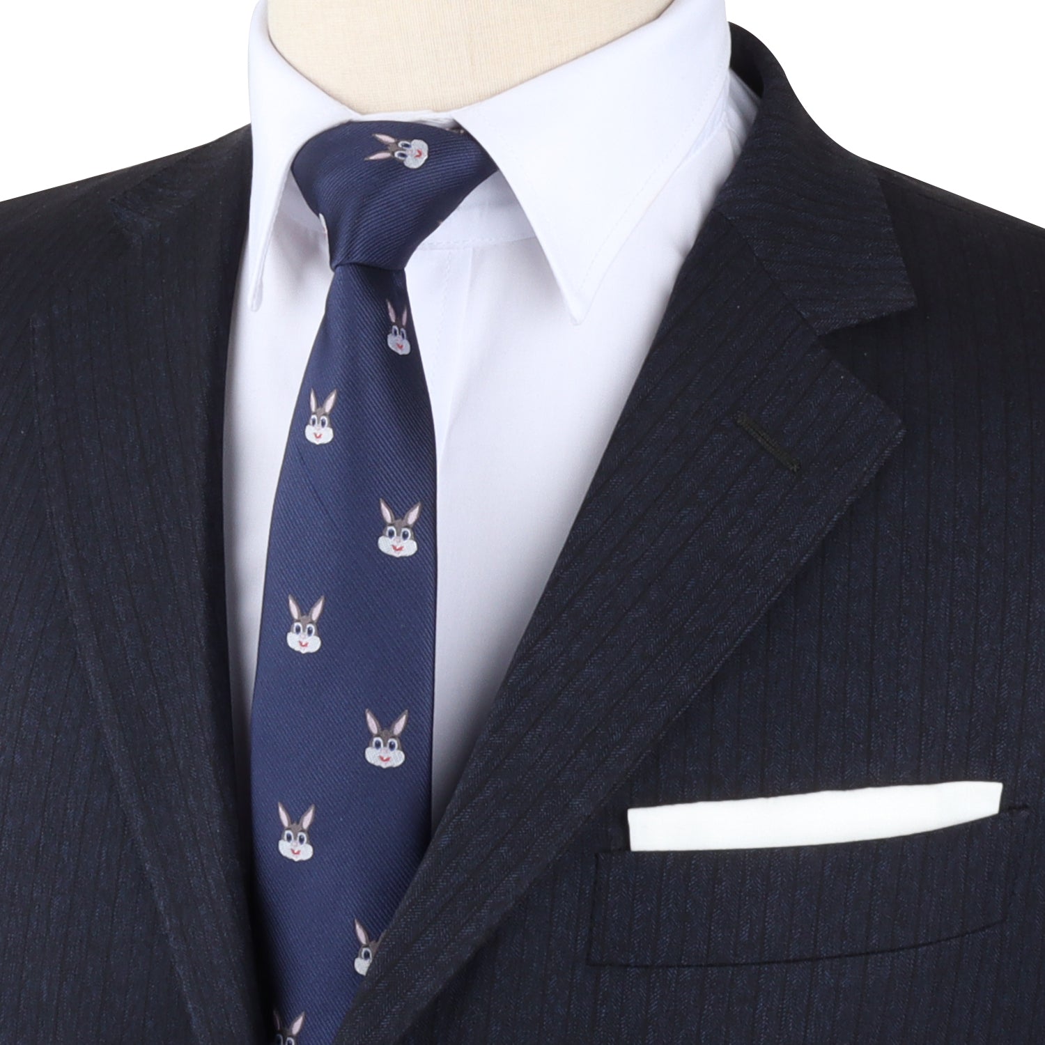 A person exudes charming sophistication in a dark pinstripe suit, paired with a crisp white shirt and the Rabbit Print Necktie in navy, adorned with a rabbit pattern.