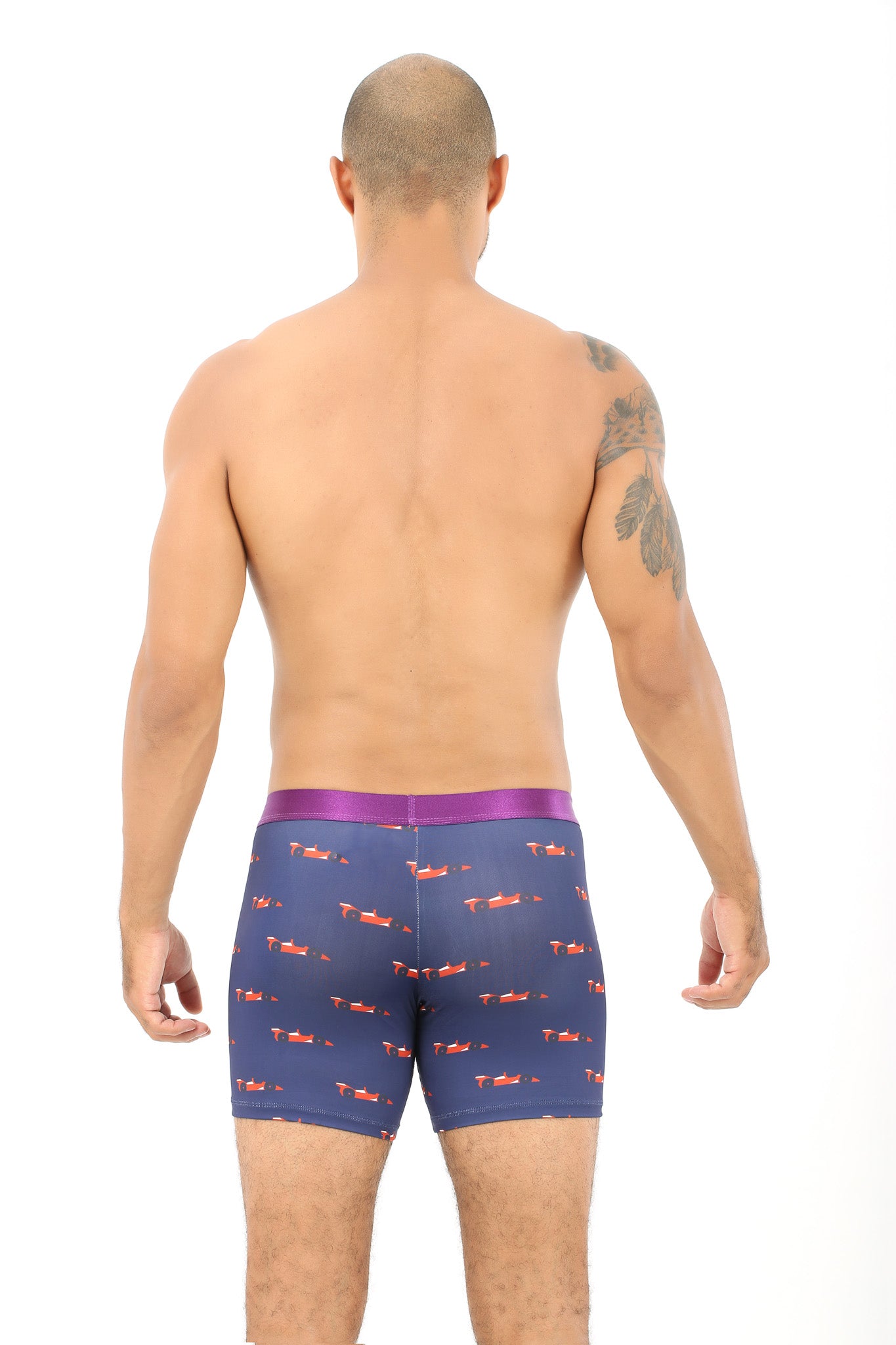 Back view of a person wearing Racing Car Themed Underwear, featuring dark blue fabric with a red dachshund pattern and a purple waistband, exuding an air of coziness.