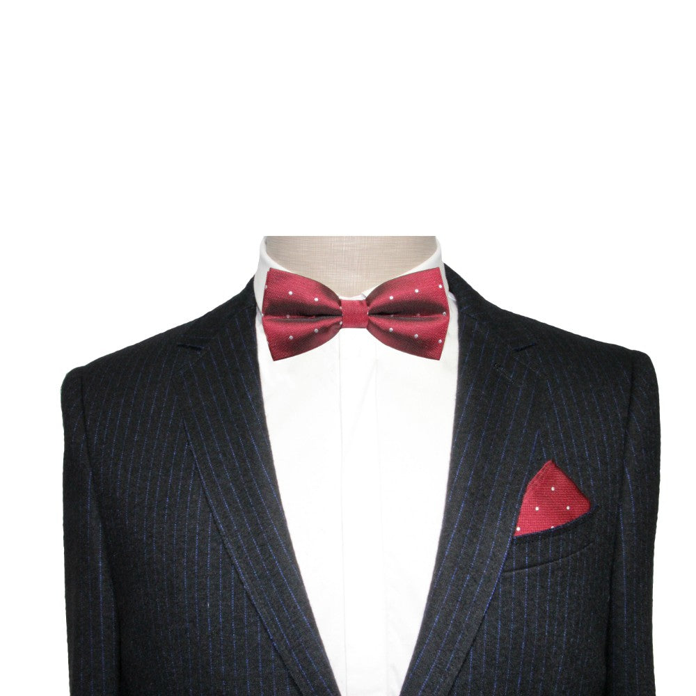 Mannequin dressed in a pinstripe suit, white shirt, and the Red White Polka Dot Bow Tie with a matching pocket square, showcasing a festive holiday style.