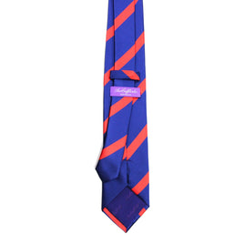The Red Stripe Navy Skinny Tie showcases a timeless style, featuring bold red diagonal stripes on a navy blue background and includes a sewn label on the back.