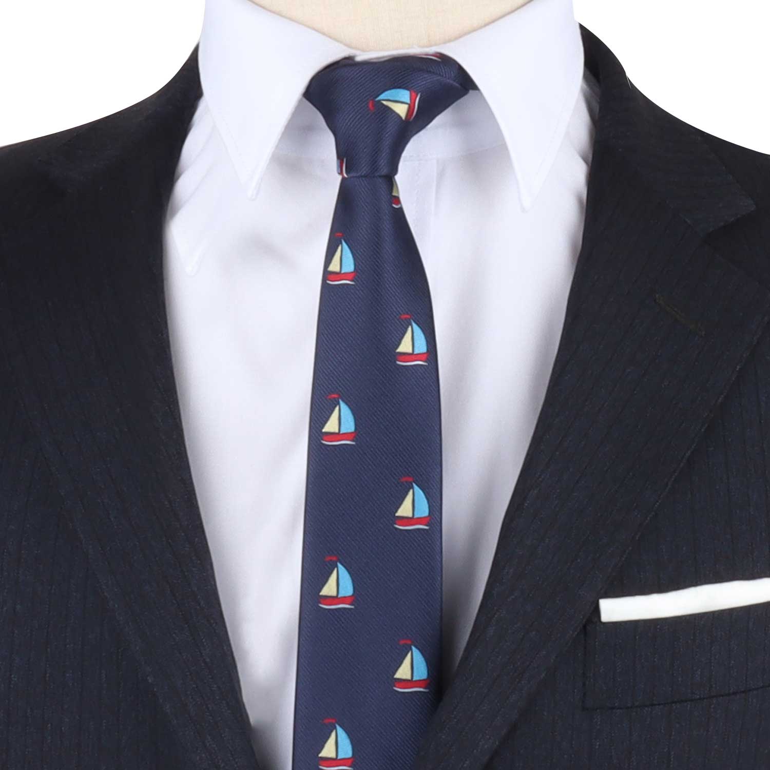 A person wearing a dark pinstripe suit and white dress shirt with the Regatta Tie, which features small sailboat designs, embracing a nautical style.