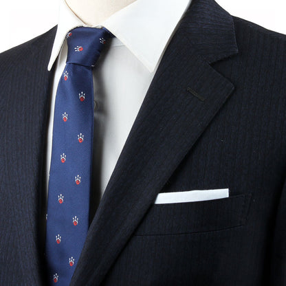 A person wearing a dark pinstripe suit jacket, white dress shirt, and the Bowling Theme Tie that features small, colorful designs, complemented by a white pocket square that harmonizes perfectly with their impeccable style.