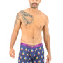 A man with a tattoo poses in Sail Boat Boxer, exuding a sense of coziness and adventure as he seems ready to navigate both life and waves.