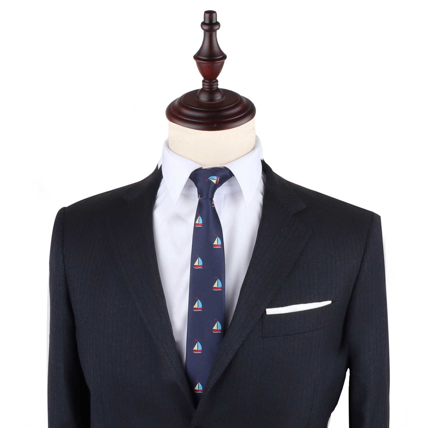 A mannequin dressed in a dark suit with a white dress shirt, the Sail Boat Slim Tie featuring small sailboat patterns, and a white pocket square embodies nautical style.