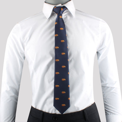 A mannequin wearing a white collared dress shirt paired with the Sandwich Tie, featuring a repeating pattern in dark blue, and dark-gray trousers exudes modern charm against a plain light gray background.