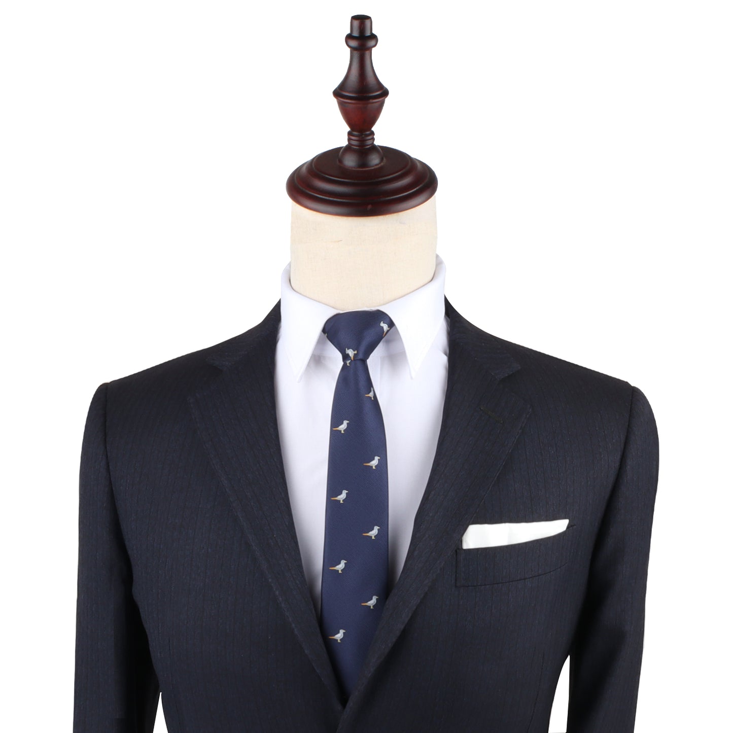 Displayed on a mannequin, a navy suit paired with a white dress shirt and the Seagul Slim Tie, which features small bird patterns, captures timeless style and lets one's confidence soar.