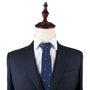 A mannequin dressed in an elegant dark pinstripe suit and crisp white dress shirt is showcased with the Great White Shark Skinny Tie, which features a subtle white shark motif, all set against a plain white background.