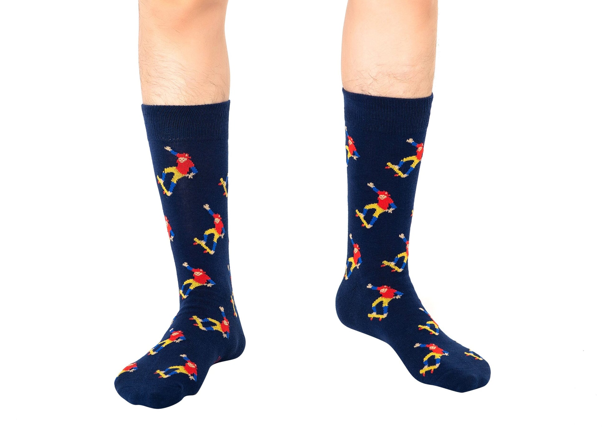 A person is sporting the Skateboarder Socks, featuring a vibrant parrot design on a navy blue background, which perfectly encapsulates a street-smart comfort vibe. Only their legs and feet are visible.