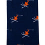 A close-up of the Ski Socks, showcasing a blue design adorned with orange and white skiing figures, blending comfort and style ideal for hitting the slopes.