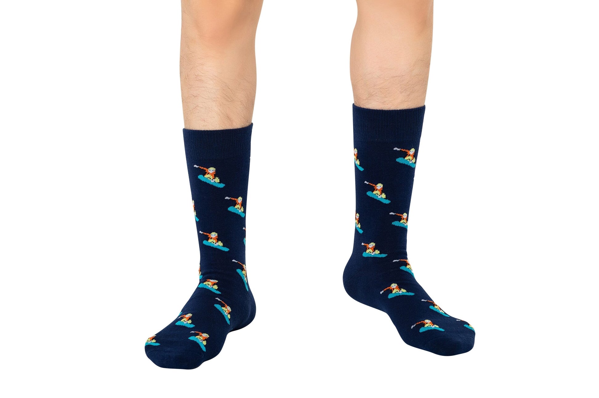 A person's legs wearing Snowboarder Socks which feature a navy blue color and a stylish alpine pattern of a person snowboarding.