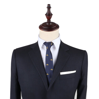 On a mannequin, a tailored navy suit showcases impeccable style with a white shirt, complemented by the Sombrero Slim Tie in navy adorned with small yellow patterns, and finished with a crisp white pocket square.