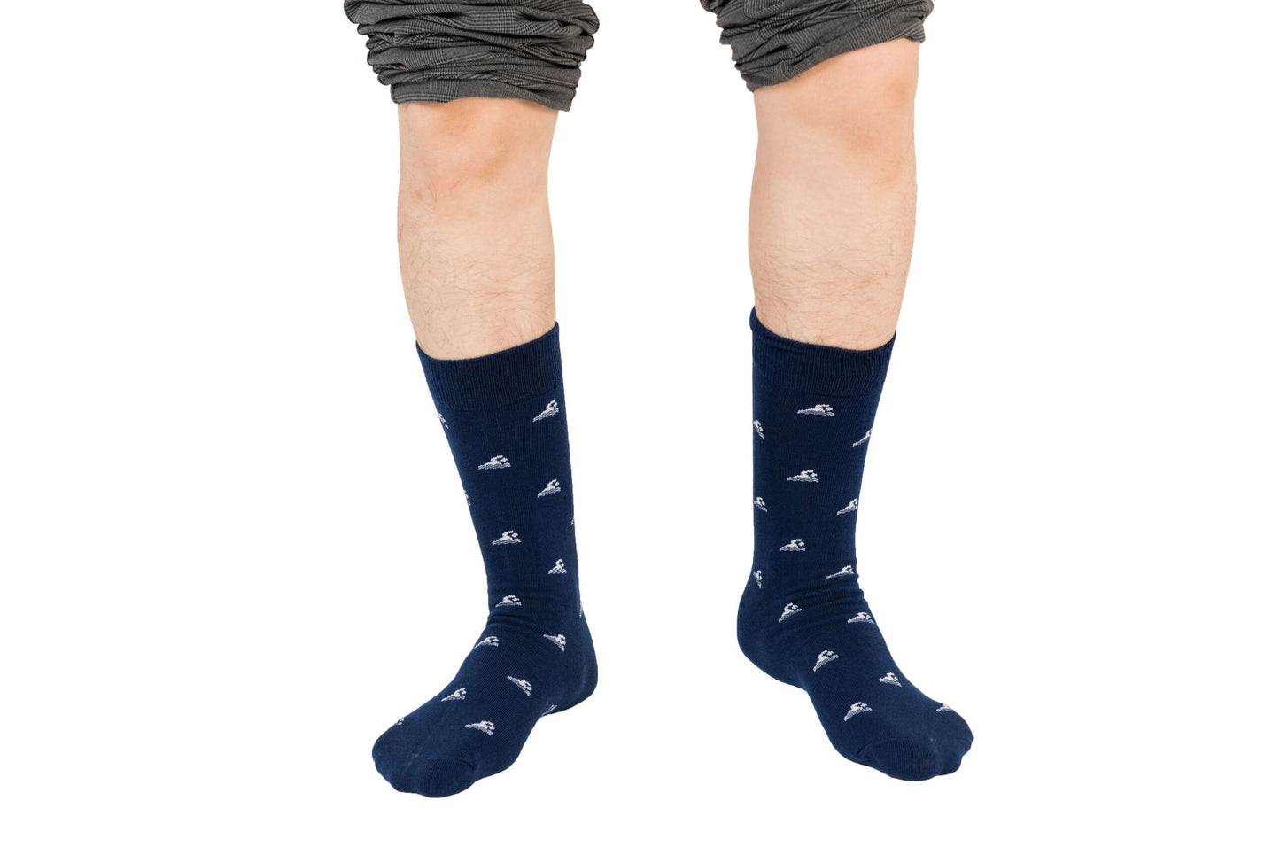 Two feet, clad in wave-washed style Swimming Socks in blue with small white patterns, stand confidently against a white backdrop, complemented by pants casually rolled up.