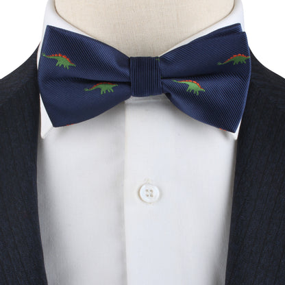 A close-up of the Stegosaurus Bow Tie, featuring a navy blue fabric adorned with small green and red dinosaur patterns, worn with a white button-up shirt and a dark jacket. This accessory adds a touch of prehistoric panache to the ensemble.