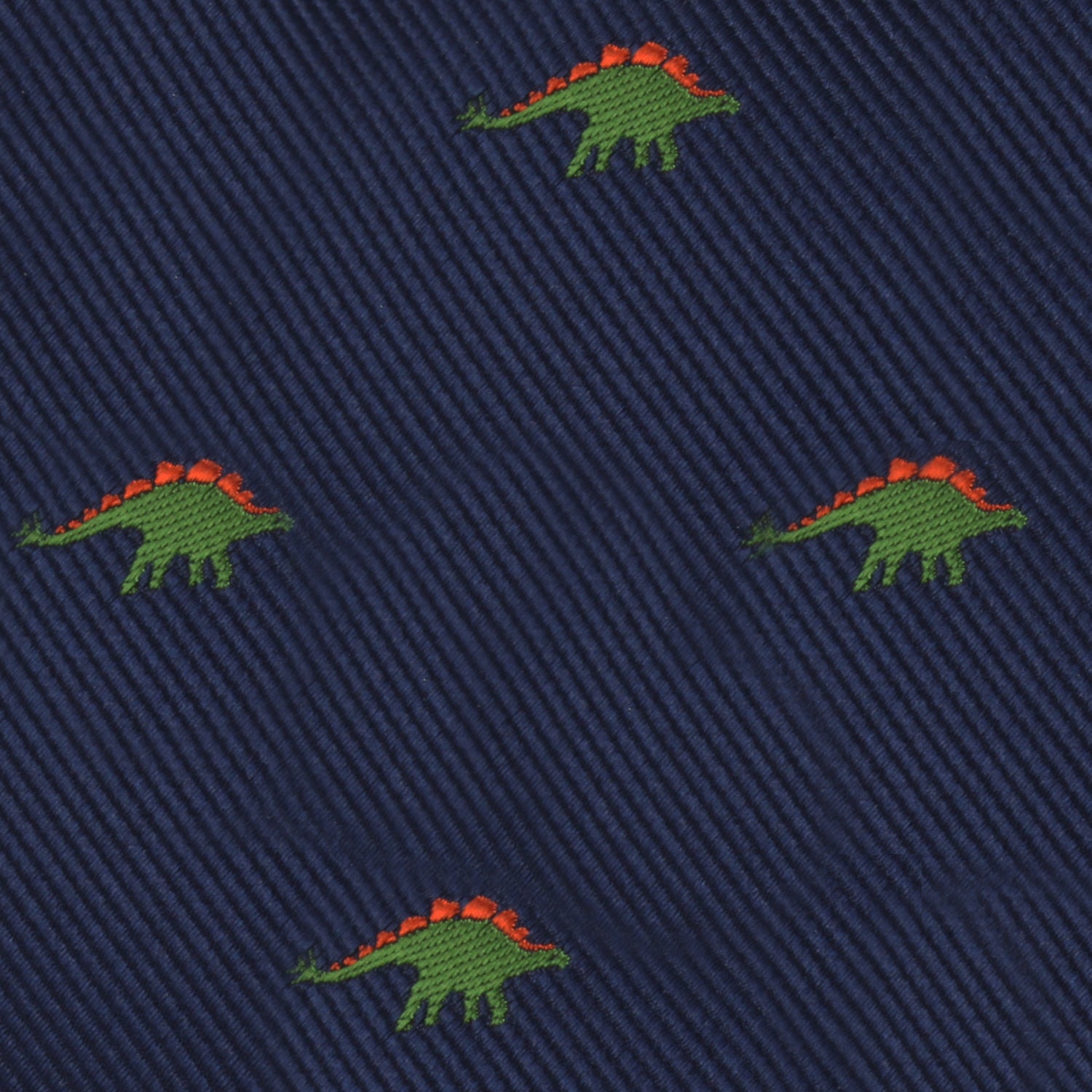 The Stegosaurus Bow Tie features a navy blue fabric adorned with small embroidered green dinosaurs, each sporting orange spines, adding a touch of prehistoric panache.
