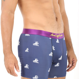 A person wearing Swimming Underwear featuring a blue patterned design and a plush purple waistband, with tattooed arm and chest partially visible, poised to dive into style.