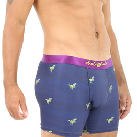 A man stands against a plain white background, wearing T-Rex Underwear with dinosaur patterns and a purple waistband, delivering roaring comfort reminiscent of prehistoric times.
