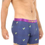 A man stands against a plain white background, wearing T-Rex Underwear with dinosaur patterns and a purple waistband, delivering roaring comfort reminiscent of prehistoric times.
