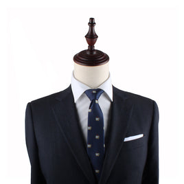A mannequin dressed in a dark suit with a white shirt and the TV Slim Tie, accessorized with a white pocket square, exudes an air of elegance perfect for any entertainment event.