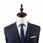 A mannequin dressed in a dark tailored suit with a white dress shirt and a Table Tennis Slim Tie exudes refined charm, topped with a wooden finial where the head would be.