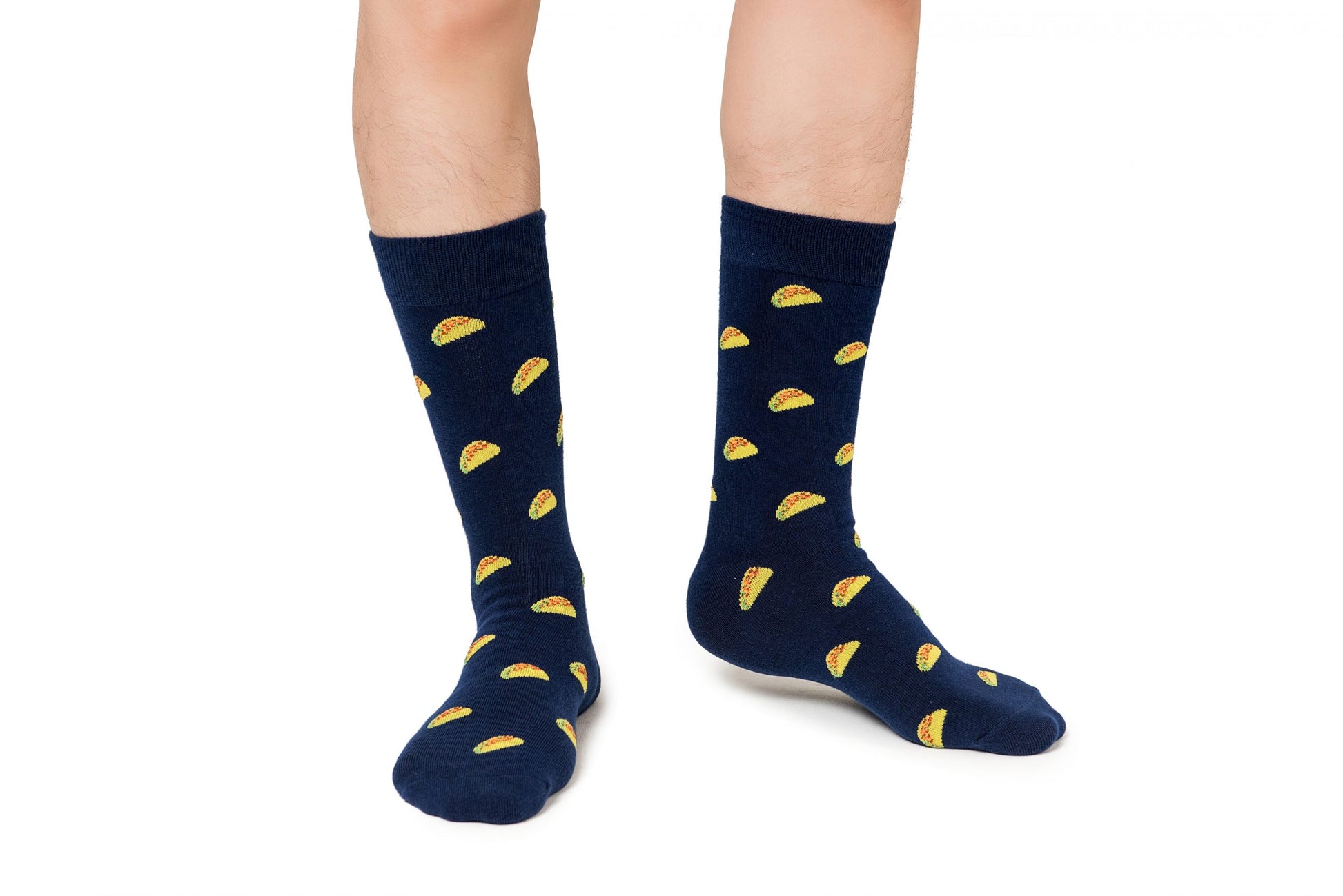 A pair of legs wearing flavor-packed Taco Socks with a playful yellow taco pattern on a white background.