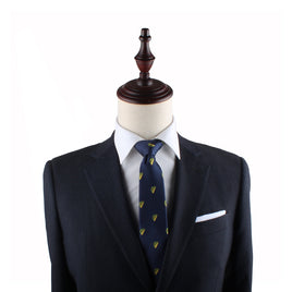 A dark suit jacket and tie on a mannequin with a wooden top, exuding modern style. The suit features a crisp white dress shirt underneath and a Taco Slim Tie in the breast pocket, creating an ensemble that's much like a sartorial Mexican delight.