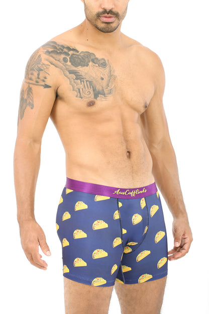A shirtless man wears the Taco Underwear, featuring navy blue boxer briefs with a taco pattern. They're perfect for taco lovers seeking moisture-wicking comfort and style in one fun package.