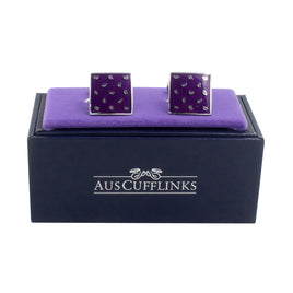 A pair of Tear Drop Purple Cufflinks on a purple display cushion exuding elegance, placed on a dark blue box labeled "AUSCUFFLINKS.