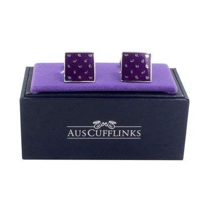 A pair of Tear Drop Purple Cufflinks on a purple display cushion exuding elegance, placed on a dark blue box labeled "AUSCUFFLINKS.