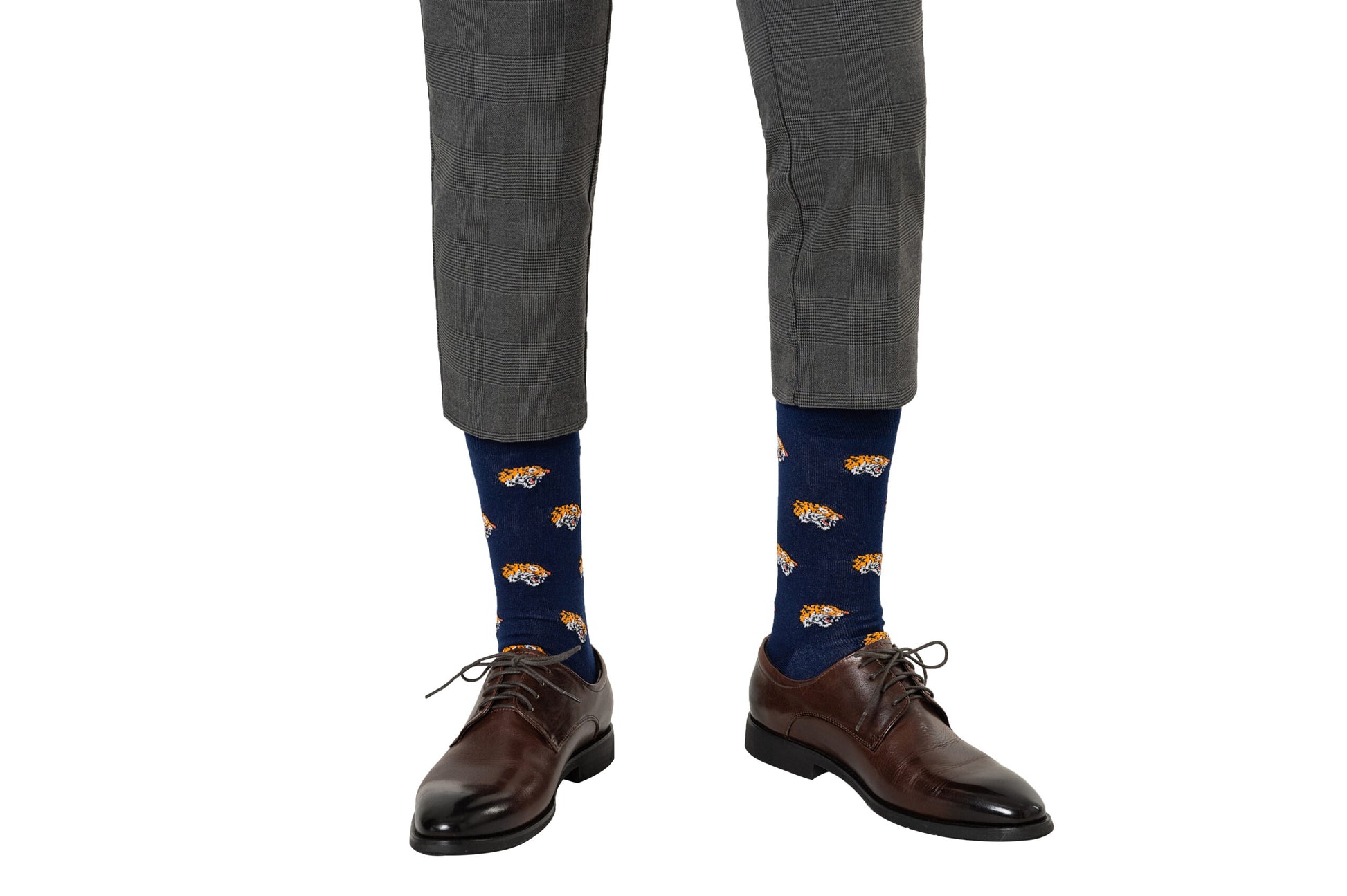 Person wearing gray pants, dark brown dress shoes, and blue Tiger Socks, adding a touch of wild comfort to their ensemble.