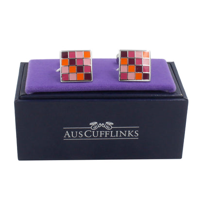 Warm Hues Cufflinks – Stylish Earthy Tones displayed on a purple pad atop a navy AUSCUFFLINKS box, featuring a modern square mosaic pattern in red, pink, and orange shades.