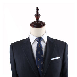 Navy blue suit jacket on a mannequin with a Watch Slim Tie, white pocket square, and a wooden neck stand against a white background, epitomizing timeless elegance.