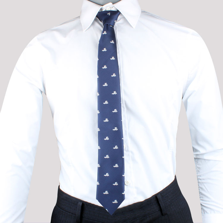 Man in a white shirt and dark trousers, wearing a Water Sports Tie with white anchor patterns, exudes timeless style.