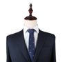 A navy blue suit with a white dress shirt and a Puppy Dog Skinny Tie, displayed on a mannequin, exudes an air of warmth perfect for dog lovers.