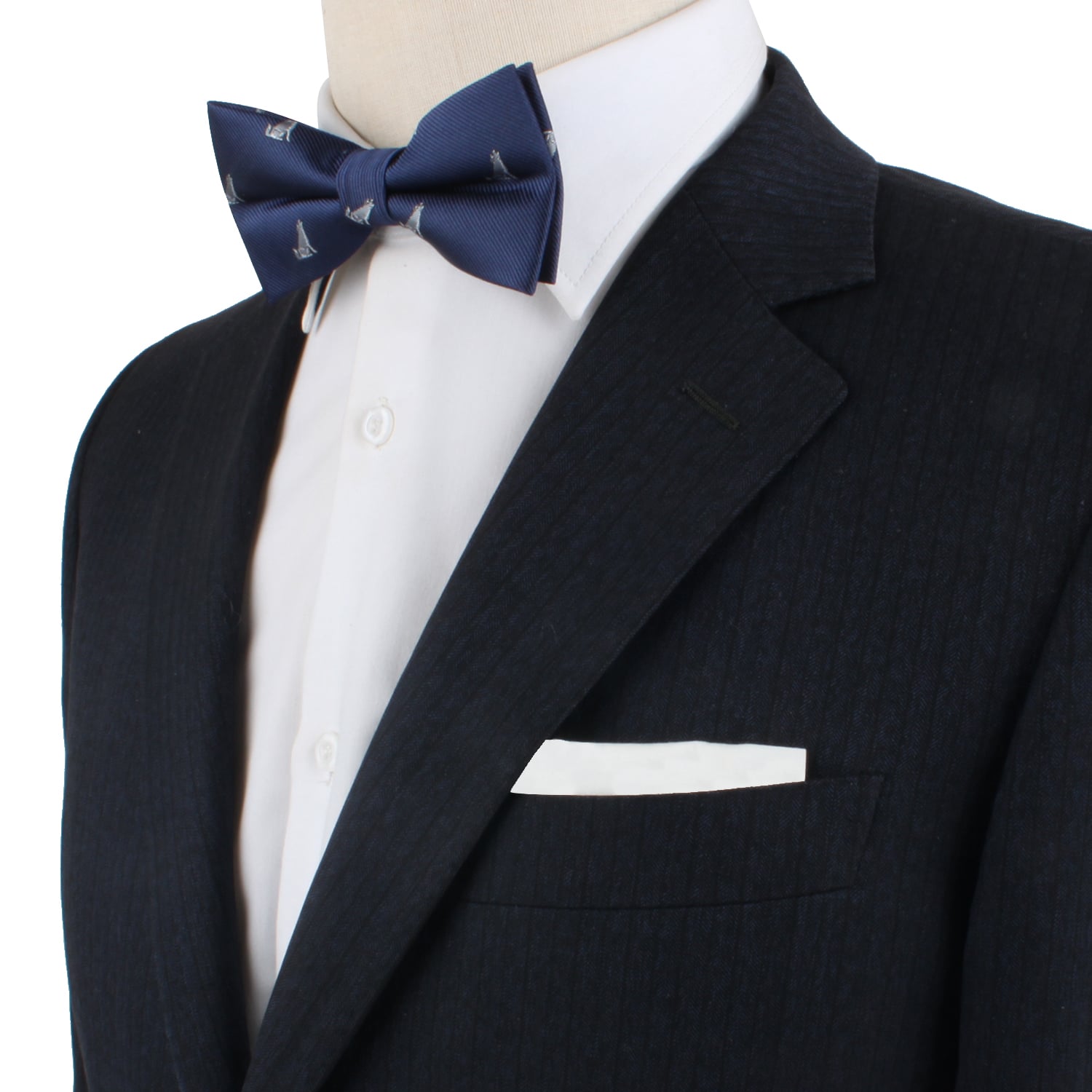 Wearing a dark pinstripe suit, an individual complemented their look with the Wolf Bow Tie, featuring small sailboat patterns, perfectly paired with a white dress shirt and pocket square.