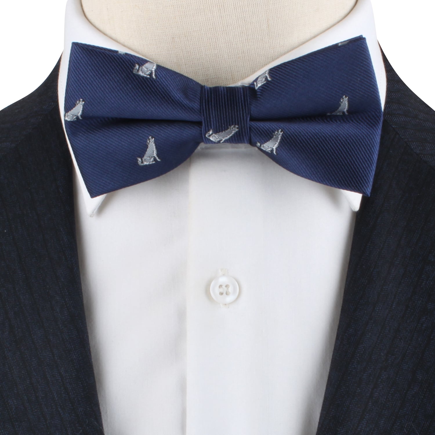 The Wolf Bow Tie, featuring a navy background with a repeating small dog pattern, becomes a statement piece when worn with a dark suit jacket and crisp white dress shirt.