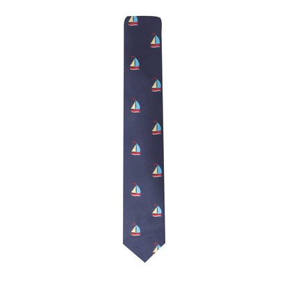 The Yacht Skinny Tie is a navy blue necktie adorned with a repeating pattern of small sailboats in red, white, and light blue colors, perfect for anyone looking to set sail with a touch of nautical style.