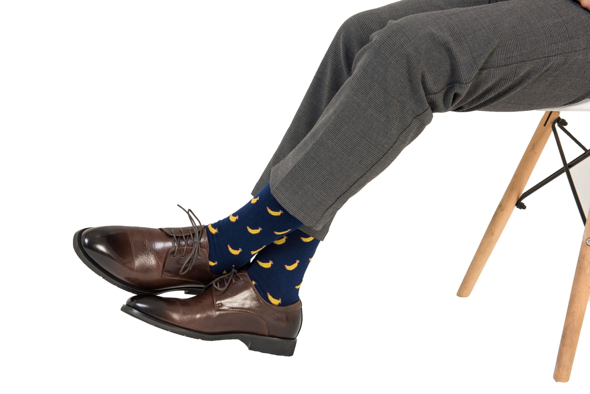 A person's legs with a pair of Banana Socks and shoes.