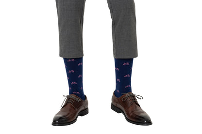 A person wearing grey plaid pants, Pink Bike Socks for a touch of whimsy, and brown leather shoes steps confidently, embracing both style and comfort with every pedal.